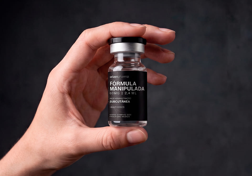 Mão segurando ampola Orizen Pharma